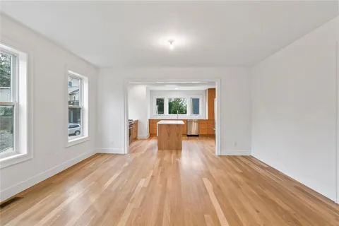 a view of kitchen with kitchen island wooden floor and refrigerator