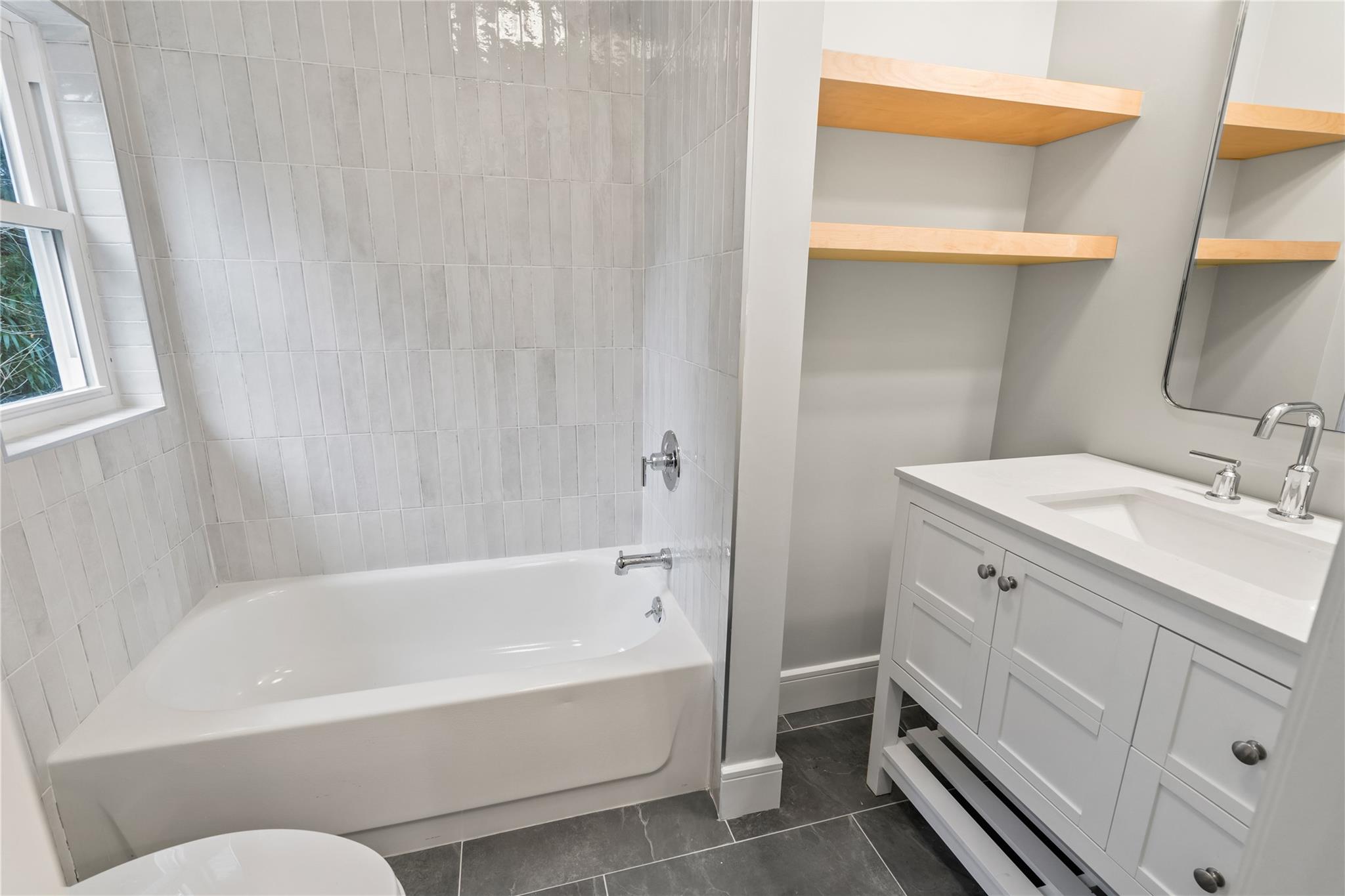 68 Glenlawn Avenue Sea Cliff, NY 11579 - Photo 41 of 49 a bathroom with a bathtub a sink a vanity and a toilet