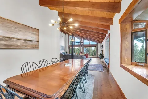 a dining room with furniture and a floor to ceiling window