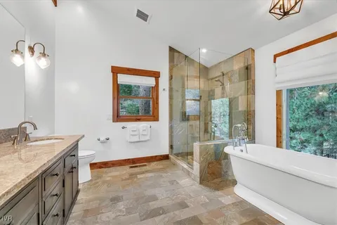 a bathroom with a granite countertop sink a large mirror and a bathtub