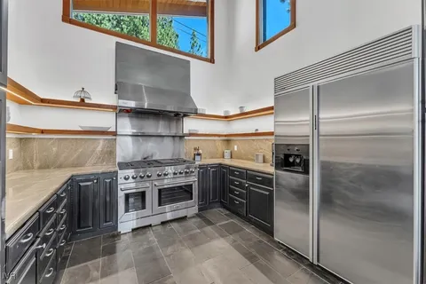 a kitchen with stainless steel appliances granite countertop a stove and a refrigerator