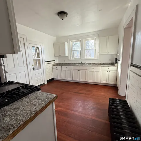 a kitchen with granite countertop a stove and a refrigerator