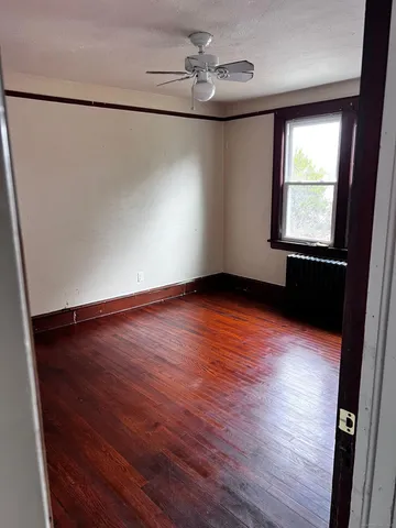 wooden floor in an empty room with a window