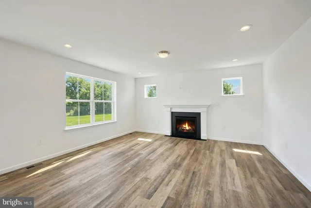 a view of empty room with wooden floor and fireplace