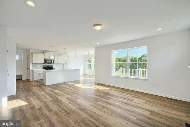 a view of kitchen with kitchen island a sink wooden floor and a refrigerator