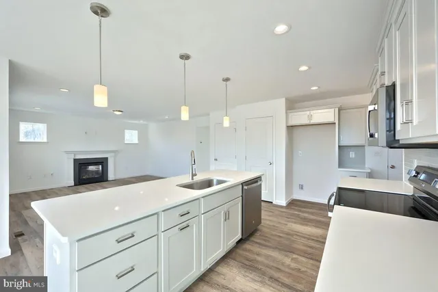 a large kitchen with kitchen island a sink stainless steel appliances and cabinets