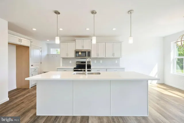 a kitchen with kitchen island a sink stainless steel appliances and cabinets
