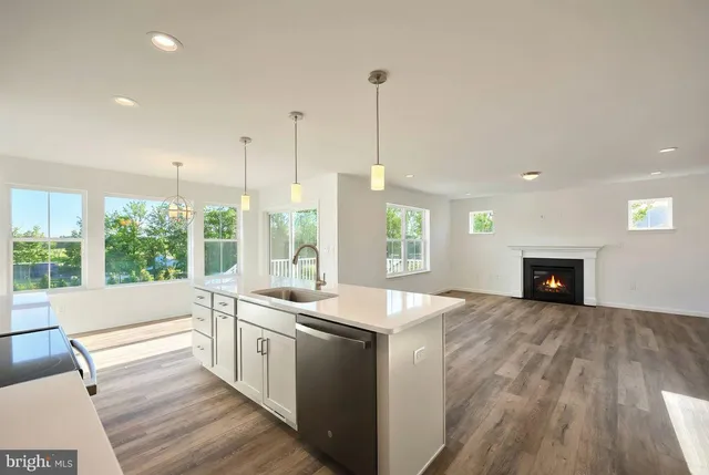 a kitchen with a sink stove and wooden floor