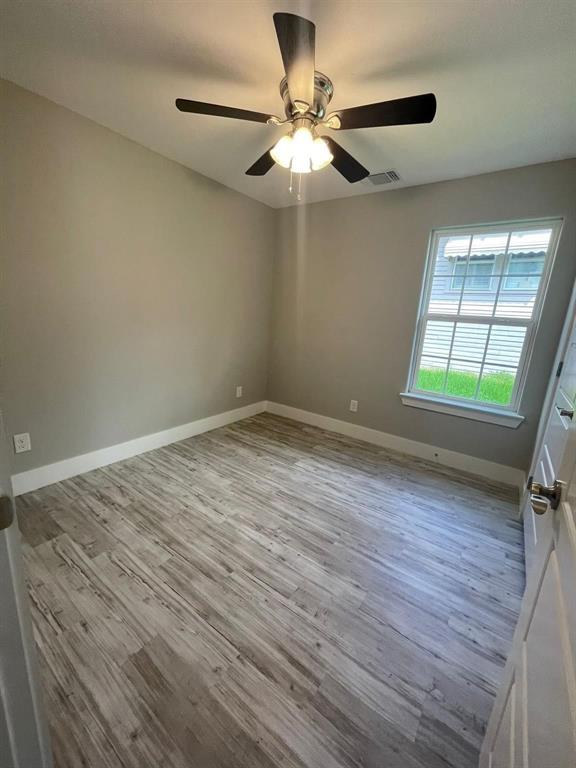 1315 West Gandy Street Denison, TX 75020 - Photo 16 of 19 wooden floor in an empty room with a window