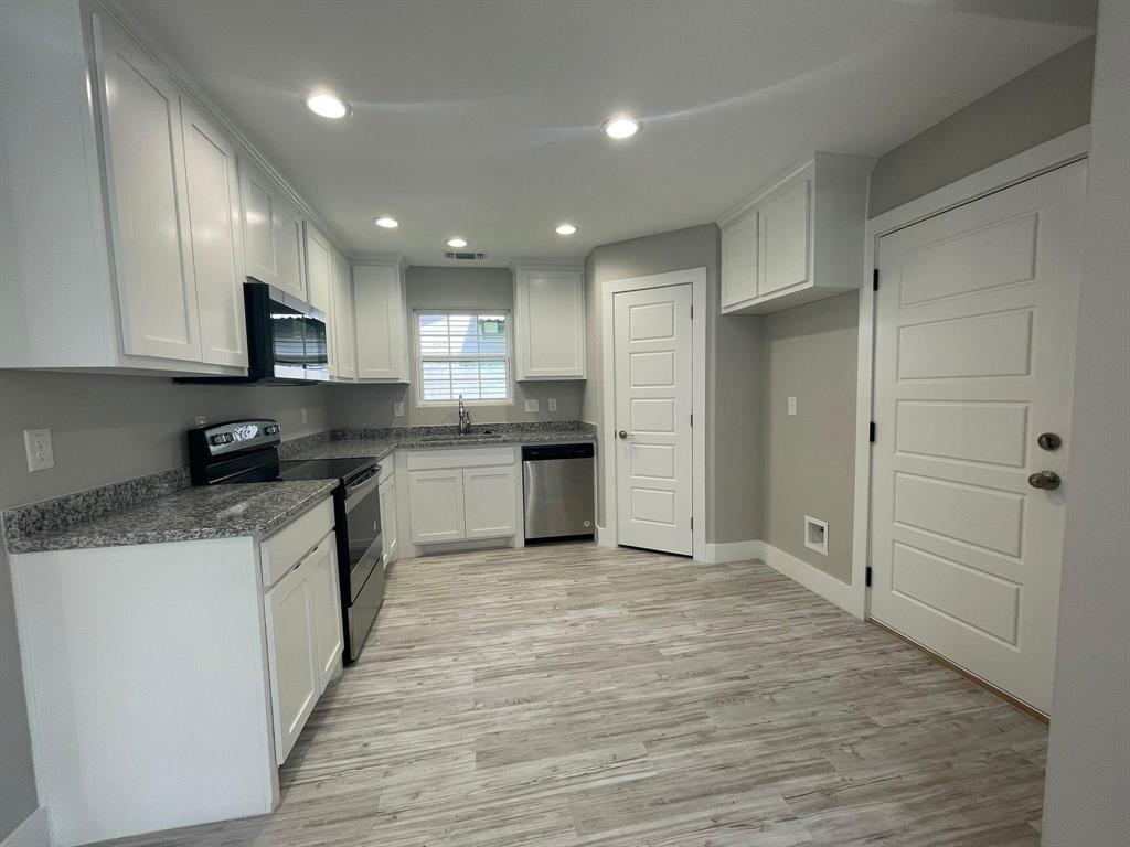 1315 West Gandy Street Denison, TX 75020 - Photo 5 of 19 a kitchen with stainless steel appliances granite countertop a stove top oven a sink and white cabinets