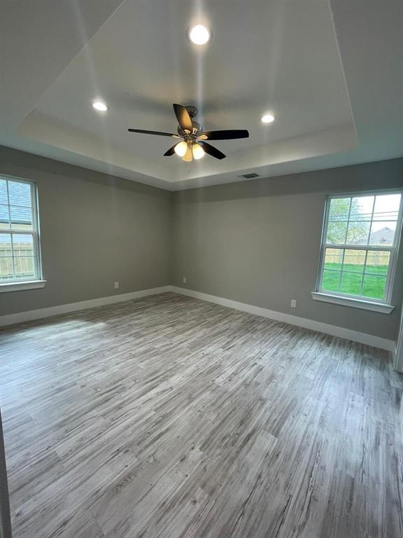 1315 West Gandy Street Denison, TX 75020 - Photo 7 of 19 an empty room with wooden floor and windows