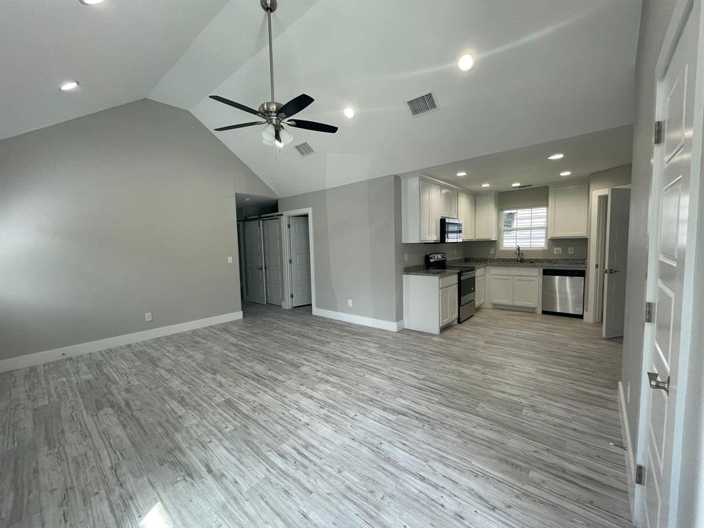 1315 West Gandy Street Denison, TX 75020 - Photo 8 of 19 a view of a kitchen with a sink stainless steel appliances and a ceiling fan