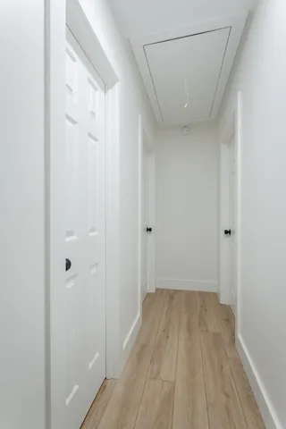 a view of a hallway with wooden floor