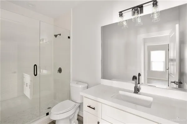 a bathroom with a sink toilet vanity and shower