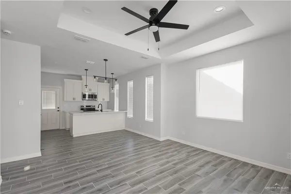 a view of a kitchen with a sink and dishwasher a refrigerator with wooden floor