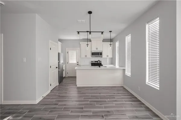 a view of a kitchen with wooden floor and a window