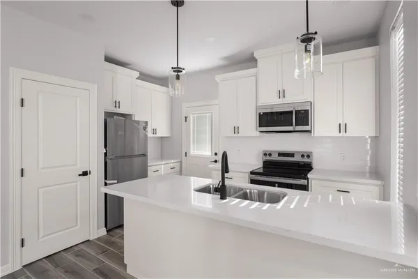 a kitchen with stainless steel appliances a refrigerator sink and microwave