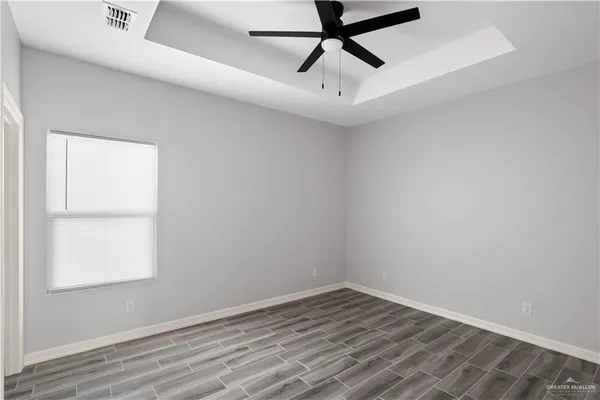 an empty room with a window and a ceiling fan