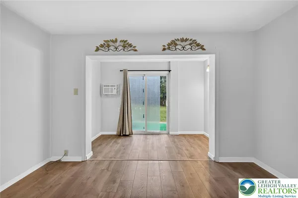 a view of an empty room with wooden floor & closet