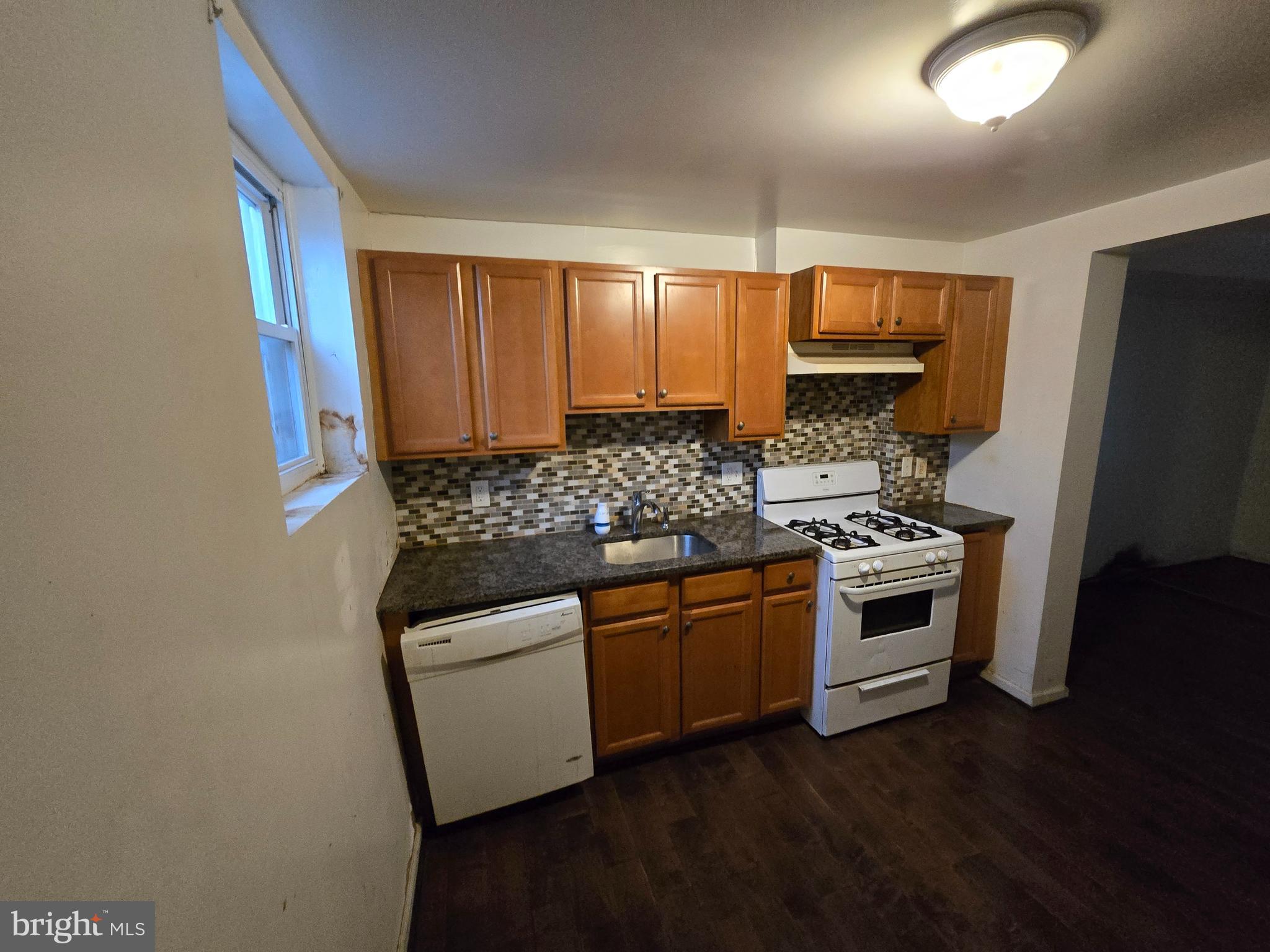 1121 Cleveland Street Baltimore, MD 21230 - Photo 5 of 13 a kitchen with granite countertop white cabinets and stainless steel appliances
