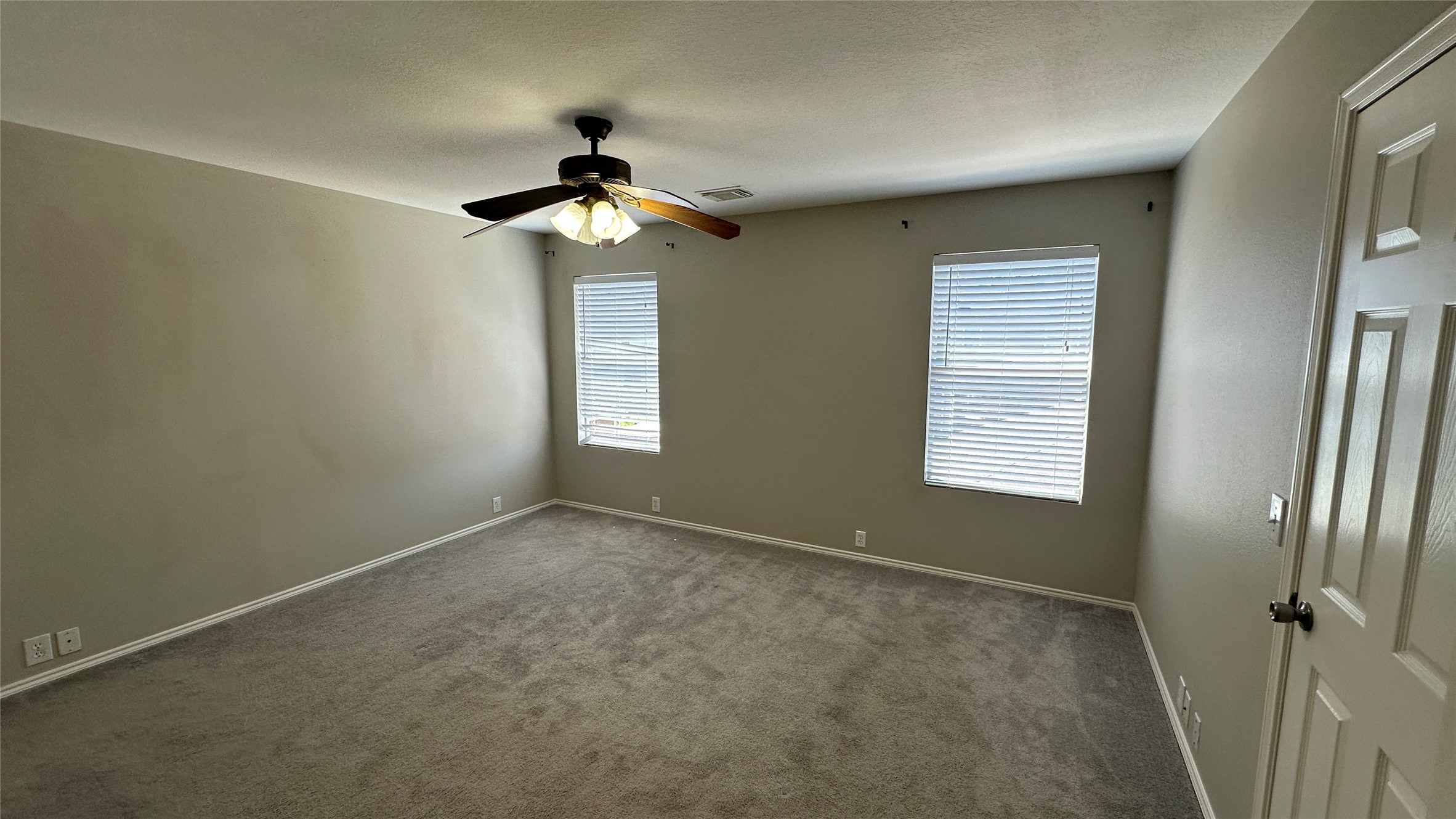 23851 Single Oak Street Spring, TX 77373 - Photo 9 of 15 an empty room with windows and fan