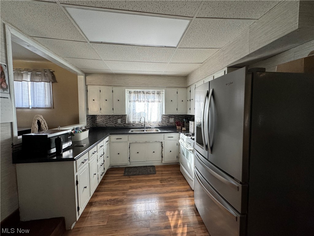 125 Sundale Road Norwich, OH 43767 - Photo 12 of 18 Kitchen featuring backsplash, white cabinets, dark hardwood / wood-style flooring, a drop ceiling, and stainless steel appliances