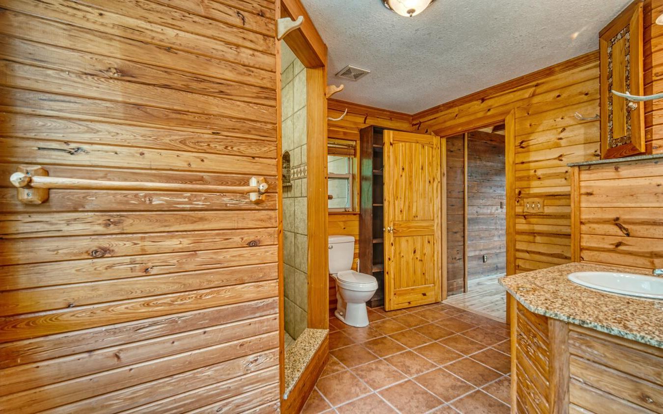 1666 Underwood Road Hiawassee, GA 30546 - Photo 15 of 42 a bathroom with a granite countertop sink and a shower