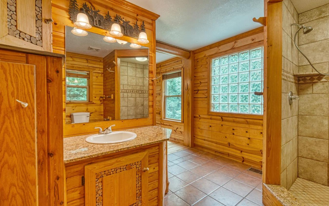 1666 Underwood Road Hiawassee, GA 30546 - Photo 17 of 42 a bathroom with a granite countertop sink and a bathtub