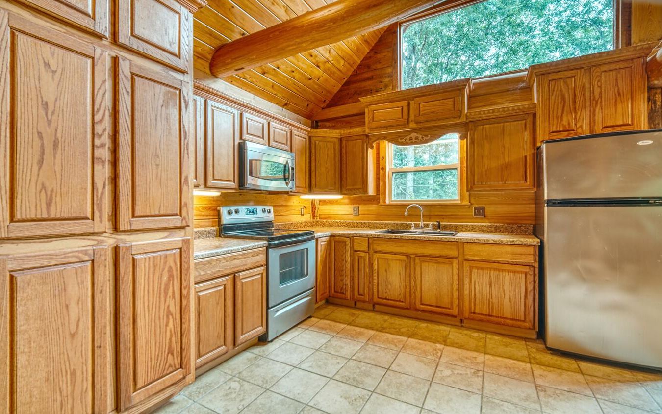 1666 Underwood Road Hiawassee, GA 30546 - Photo 9 of 42 a kitchen with stainless steel appliances granite countertop a refrigerator a sink dishwasher and white cabinets with wooden floor