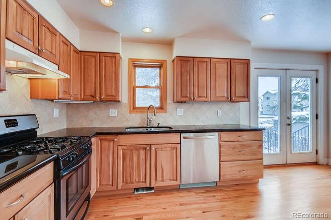 380 County Road Louisville, CO 80027 - Photo 11 of 28 a kitchen with granite countertop wooden cabinets and a stove