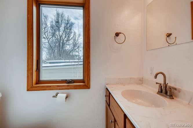 380 County Road Louisville, CO 80027 - Photo 12 of 28 a bathroom with a granite countertop sink and mirror with window