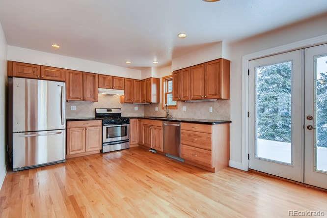 380 County Road Louisville, CO 80027 - Photo 8 of 28 a kitchen with granite countertop wooden floors stainless steel appliances and window