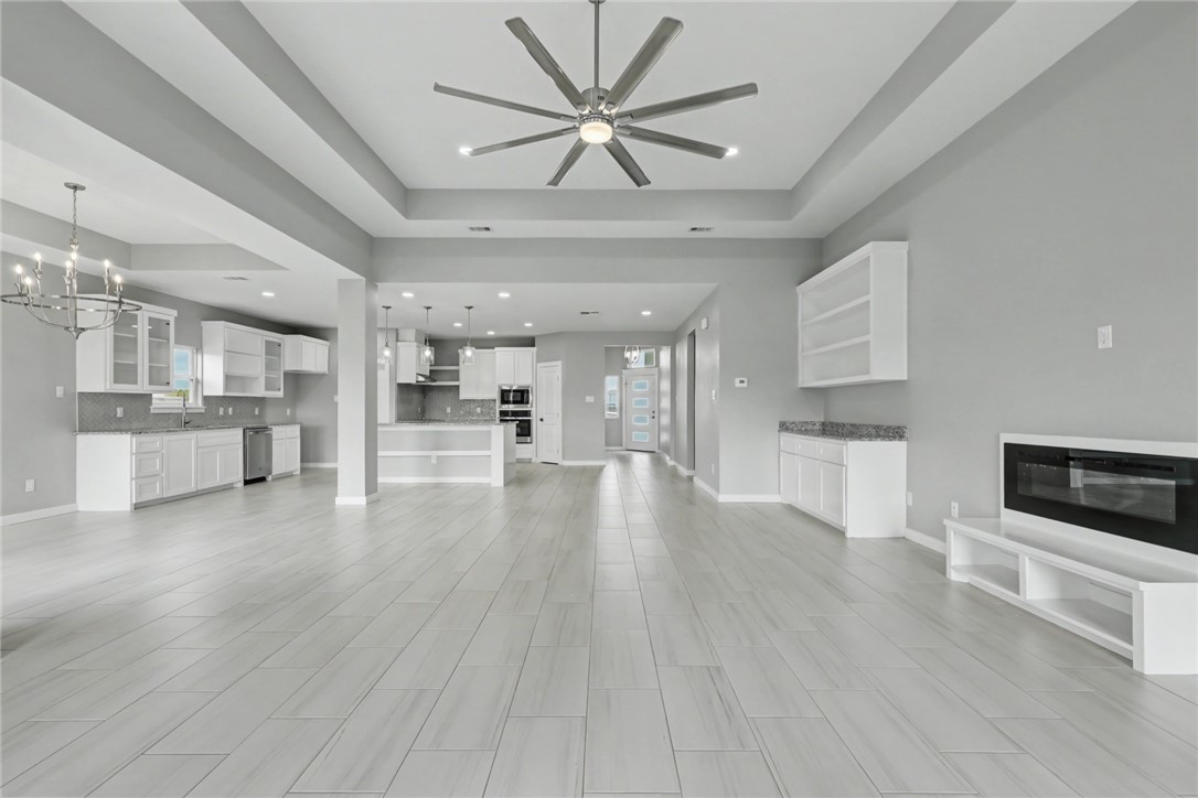 6865 Riesling Street Corpus Christi, TX 78414 - Photo 8 of 32 a view of an empty room and kitchen with wooden floor