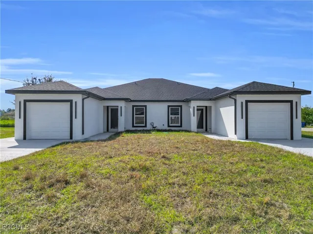 a view of a house with a yard and garage