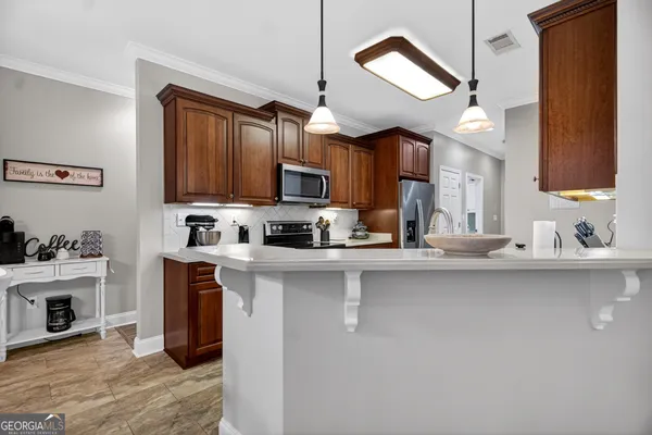 a kitchen with stainless steel appliances granite countertop a refrigerator stove top oven and sink