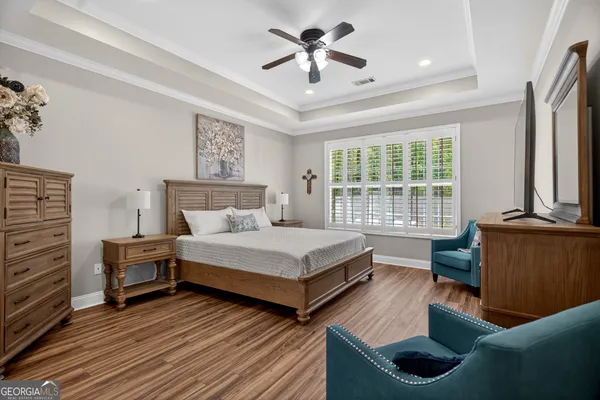 a living room with furniture a flat screen tv and a floor to ceiling window