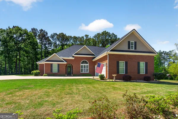 a front view of a house with a yard and trees