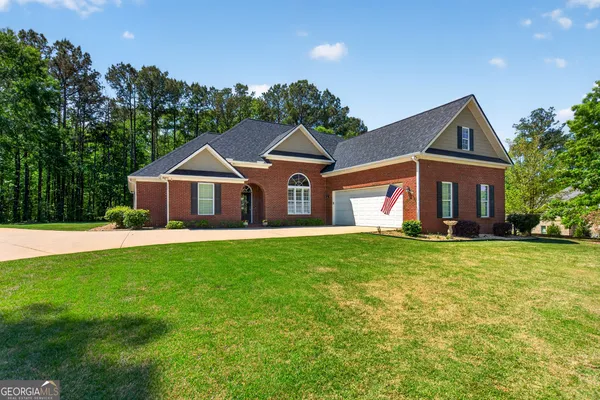 a front view of a house with a yard and trees