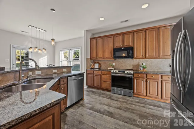 a view of a dining room with furniture a chandelier and wooden floor