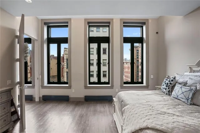 a bedroom with a bed and a large window