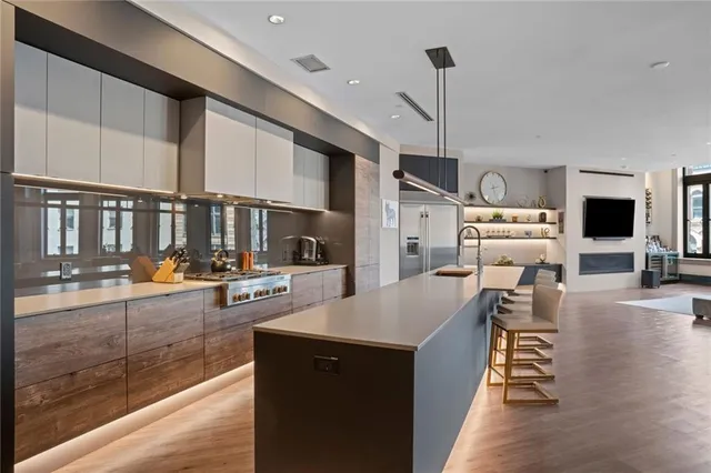a kitchen with stainless steel appliances kitchen island granite countertop a sink stove and wooden floor