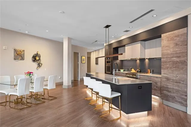 a kitchen with stainless steel appliances a sink cabinets and wooden floor