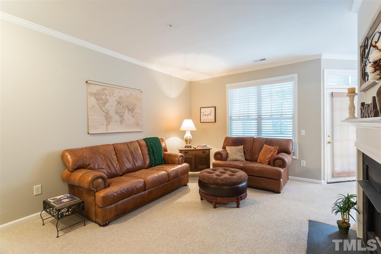 3151 Hemlock Forest Circle, Unit 102 Raleigh, NC 27612 - Photo 11 of 26 a living room with furniture a fireplace and a window