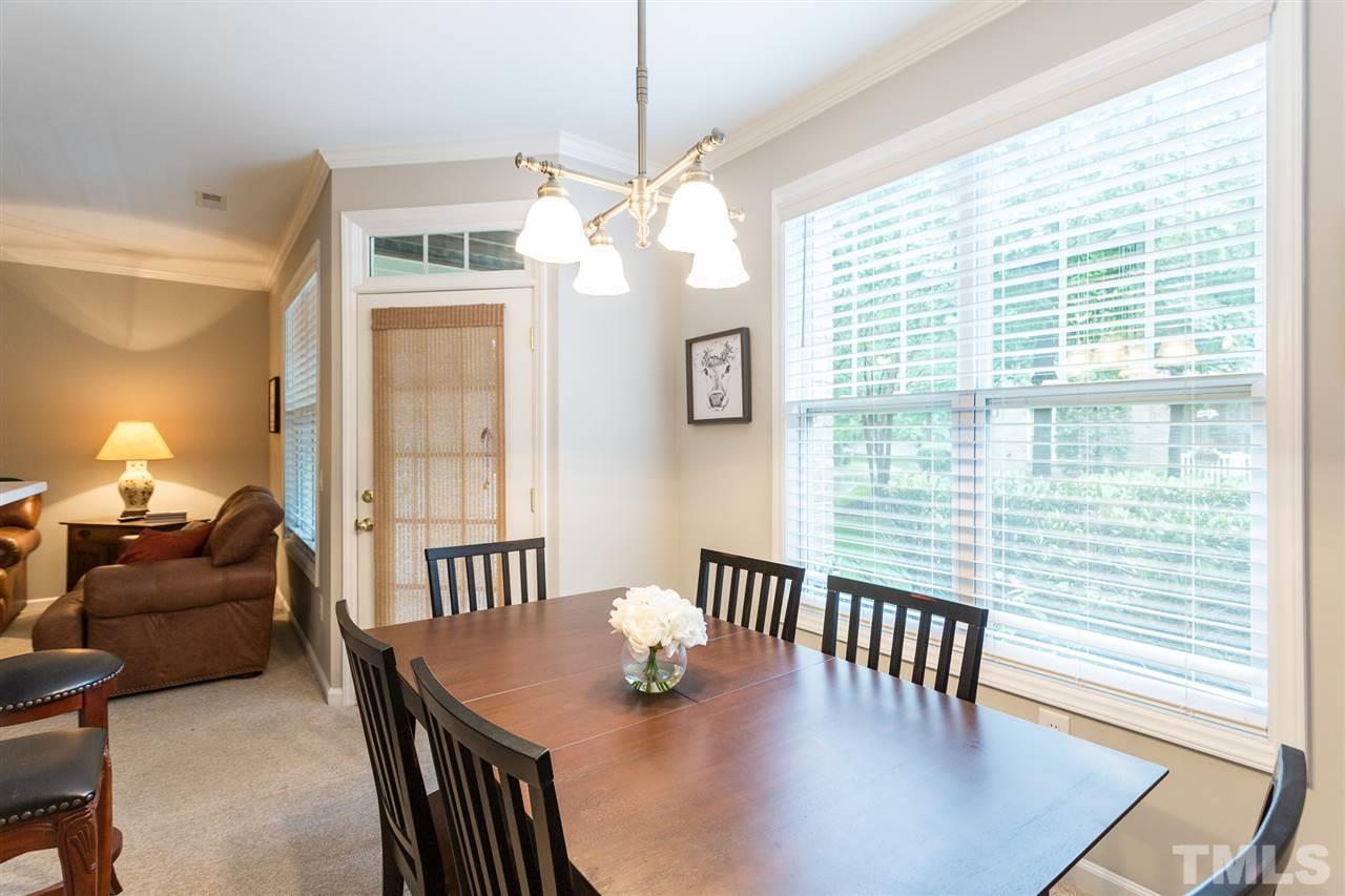 3151 Hemlock Forest Circle, Unit 102 Raleigh, NC 27612 - Photo 14 of 26 a dining room with furniture a chandelier and wooden floor