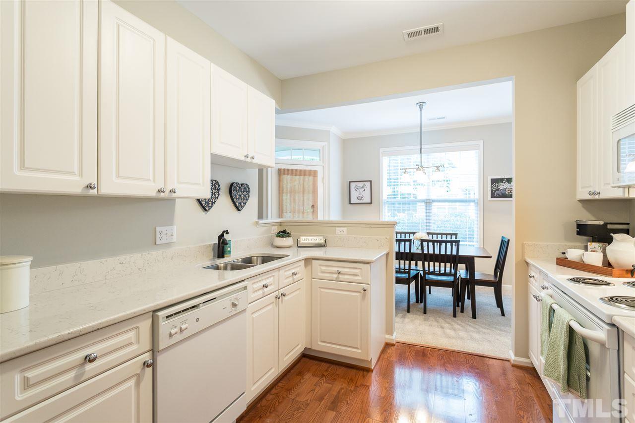 3151 Hemlock Forest Circle, Unit 102 Raleigh, NC 27612 - Photo 17 of 26 a kitchen with a sink cabinets and wooden floor