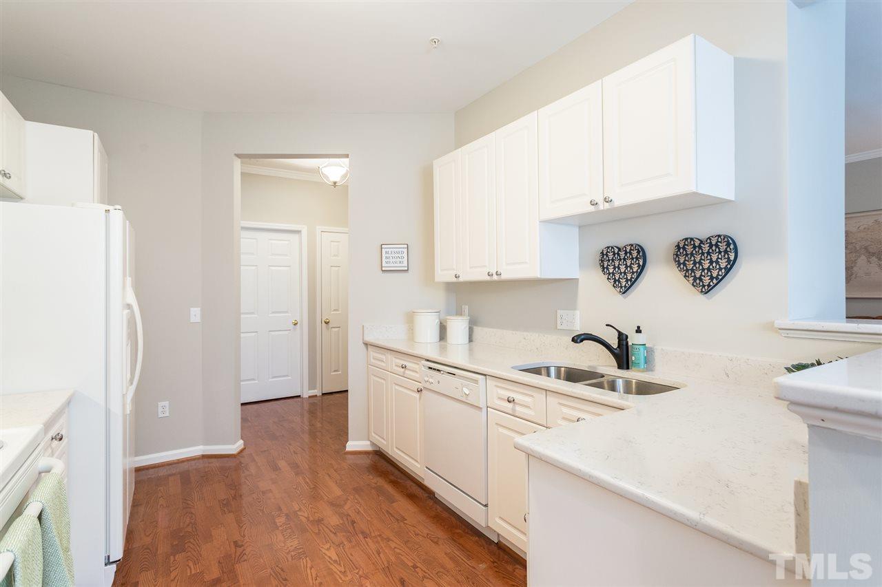 3151 Hemlock Forest Circle, Unit 102 Raleigh, NC 27612 - Photo 23 of 26 a kitchen with a sink and a refrigerator