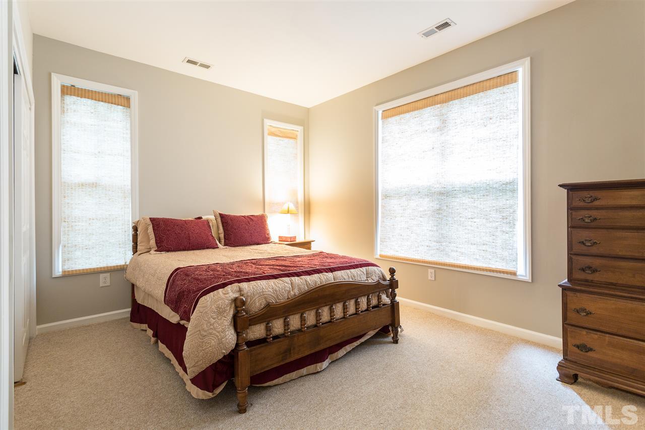 3151 Hemlock Forest Circle, Unit 102 Raleigh, NC 27612 - Photo 24 of 26 a spacious bedroom with a bed and a window