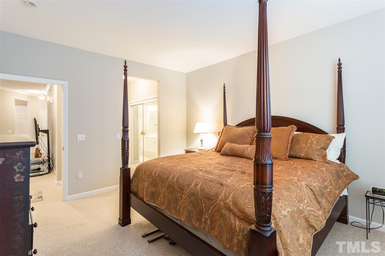 3151 Hemlock Forest Circle, Unit 102 Raleigh, NC 27612 - Photo 25 of 26 a bedroom with a large bed and a closet