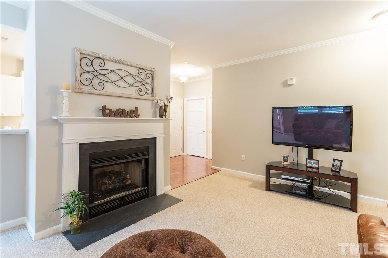3151 Hemlock Forest Circle, Unit 102 Raleigh, NC 27612 - Photo 9 of 26 a living room with furniture a fireplace and a flat screen tv