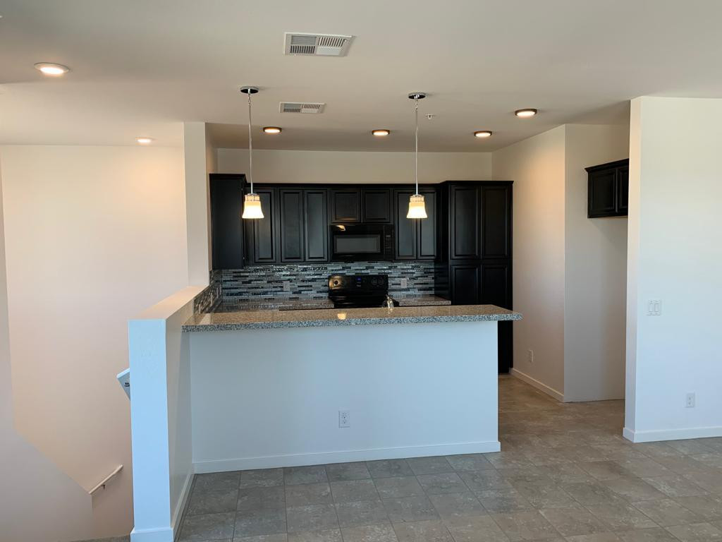 a view of kitchen with stainless steel appliances kitchen island a sink dishwasher a refrigerator and a fireplace